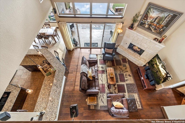 406 Breathless View St, San Antonio, TX 78260 - living area featuring a tiled fireplace, a high ceiling, wood finished floors, and a textured wall