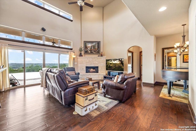 406 Breathless View St, San Antonio, TX 78260 - living room with arched walkways, a high ceiling, a stone fireplace, ceiling fan, and dark wood finished floors