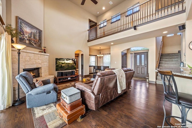 406 Breathless View St, San Antonio, TX 78260 - living area with arched walkways, hardwood / wood-style flooring, a stone fireplace, a towering ceiling, and stairway