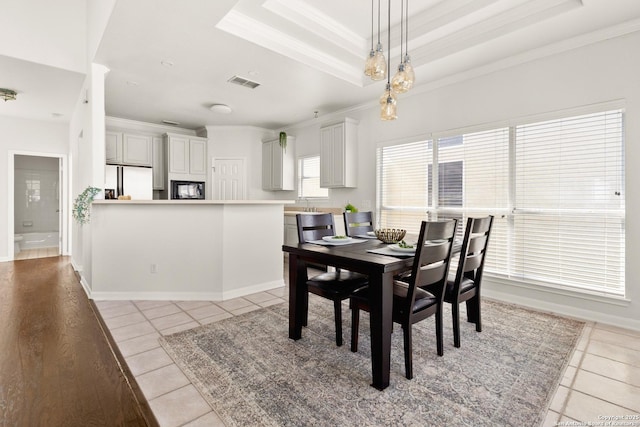 116 Seth Raynor, New Braunfels, TX 78130 - dining area featuring crown molding, light tile patterned floors, a raised ceiling, and baseboards