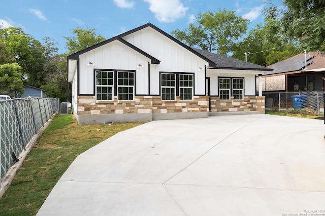 127 Hopi, San Antonio, TX 78211 - rear view of property with board and batten siding, central air condition unit, a shingled roof, and stone siding