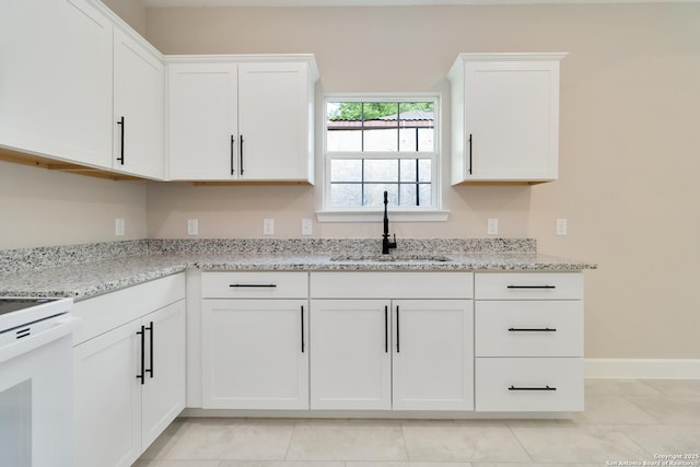 127 Hopi, San Antonio, TX 78211 - kitchen featuring a sink, white cabinets, range, and light stone countertops
