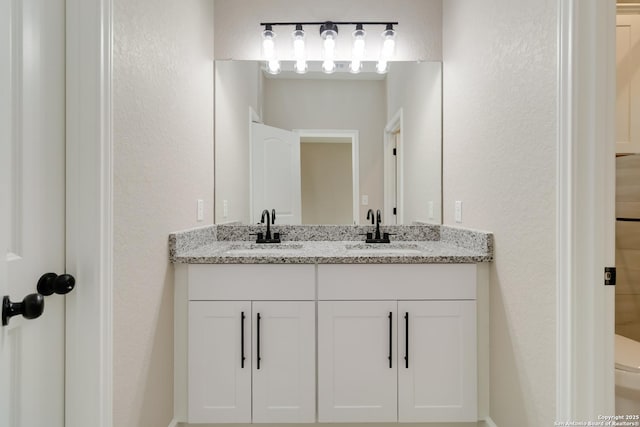 127 Hopi, San Antonio, TX 78211 - bathroom with double vanity, a textured wall, and toilet