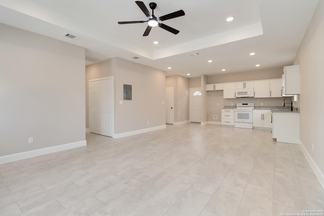 127 Hopi, San Antonio, TX 78211 - unfurnished living room with a tray ceiling, ceiling fan, recessed lighting, a sink, and baseboards