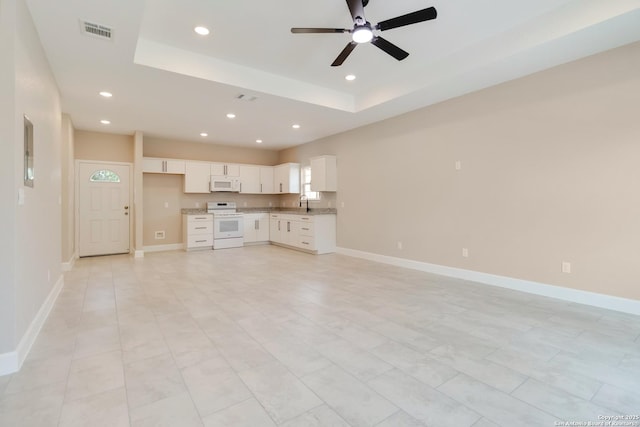 127 Hopi, San Antonio, TX 78211 - unfurnished living room with a ceiling fan, recessed lighting, a tray ceiling, a sink, and baseboards