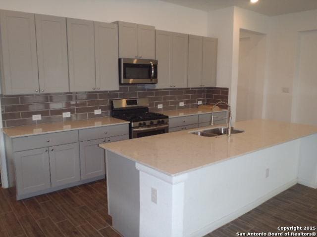 5919 Corsicana, Seguin, TX 78155 - kitchen with stainless steel appliances, a sink, gray cabinetry, and dark wood-style flooring