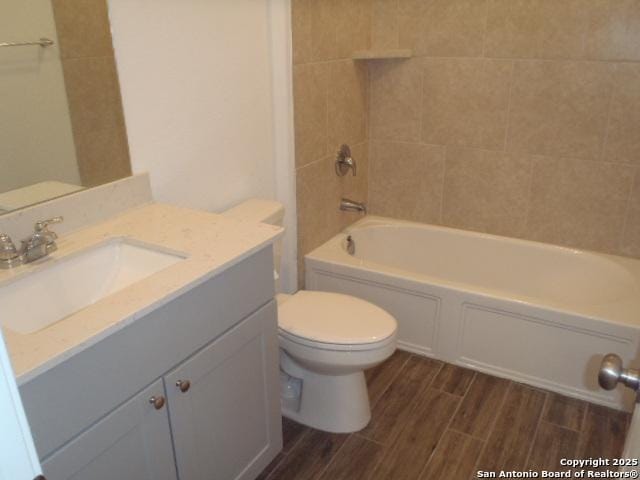 5919 Corsicana, Seguin, TX 78155 - bathroom featuring toilet, vanity, wood finished floors, and shower / tub combination