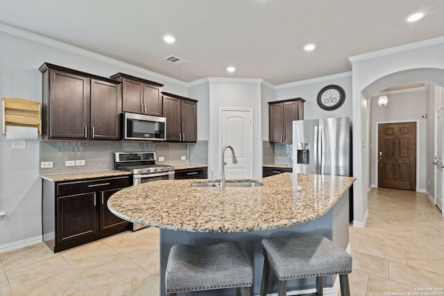 13818 Cohan Way, San Antonio, TX 78253 - kitchen with stainless steel appliances, a sink, arched walkways, dark brown cabinets, and recessed lighting