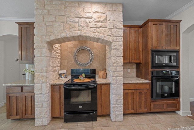 154 Lake View Dr, Boerne, TX 78006 - kitchen with black appliances, ornamental molding, brown cabinets, light stone countertops, and baseboards