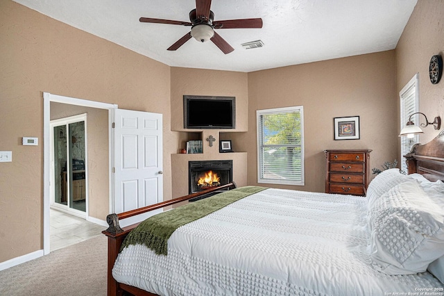 177 Ten W Dr, Comfort, TX 78013 - carpeted bedroom featuring a textured wall, a lit fireplace, baseboards, and ceiling fan