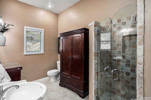177 Ten W Dr, Comfort, TX 78013 - bathroom with a stall shower, toilet, tile patterned floors, a sink, and a textured wall