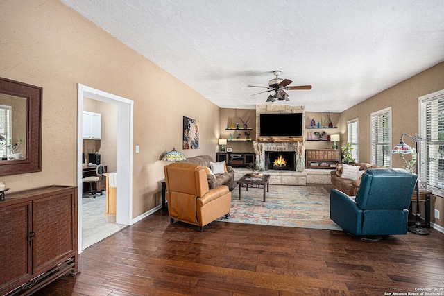 177 Ten W Dr, Comfort, TX 78013 - living room featuring dark wood finished floors, ceiling fan, a textured ceiling, a fireplace, and baseboards