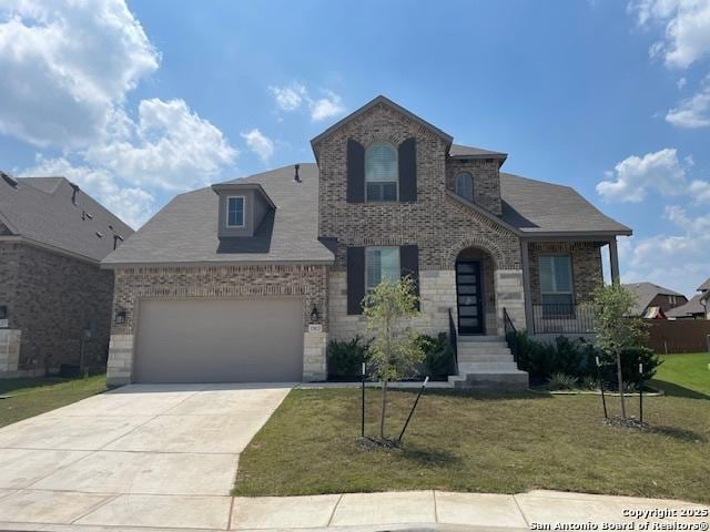 12023 Horseshoe, San Antonio, TX 78254 - view of front of property with a front yard, concrete driveway, brick siding, and an attached garage