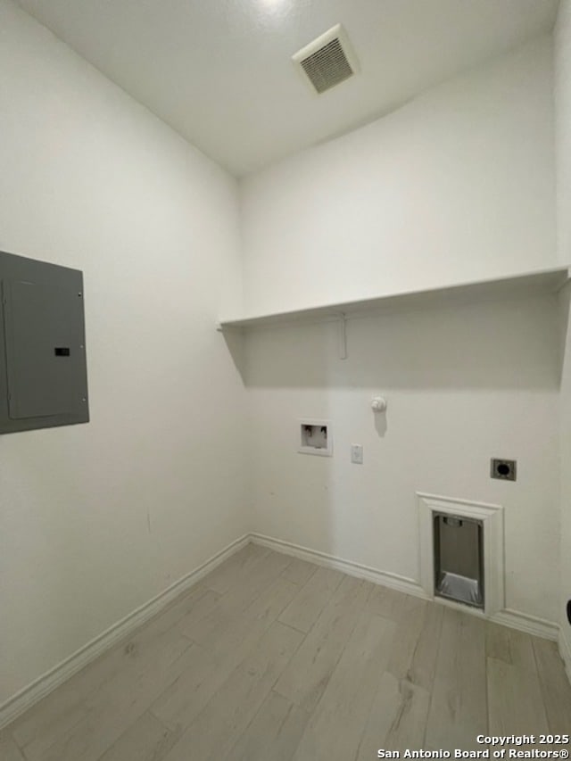 12023 Horseshoe, San Antonio, TX 78254 - laundry area featuring electric panel, electric dryer hookup, hookup for a gas dryer, washer hookup, and light wood-style flooring