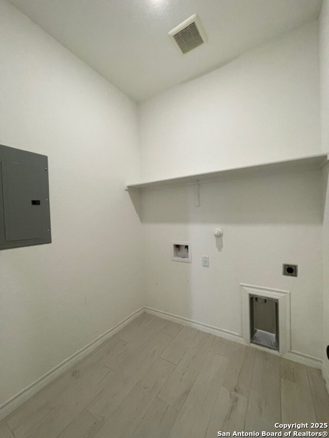12023 Horseshoe, San Antonio, TX 78254 - laundry room with electric panel, electric dryer hookup, gas dryer hookup, hookup for a washing machine, and light wood-style flooring