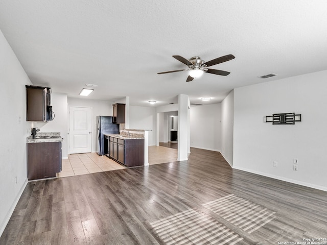 7071 Capeshaw, San Antonio, TX 78252 - unfurnished living room with a sink, ceiling fan, light wood-type flooring, and baseboards