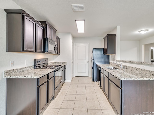 7071 Capeshaw, San Antonio, TX 78252 - kitchen with black appliances, a sink, light tile patterned flooring, light stone counters, and a peninsula