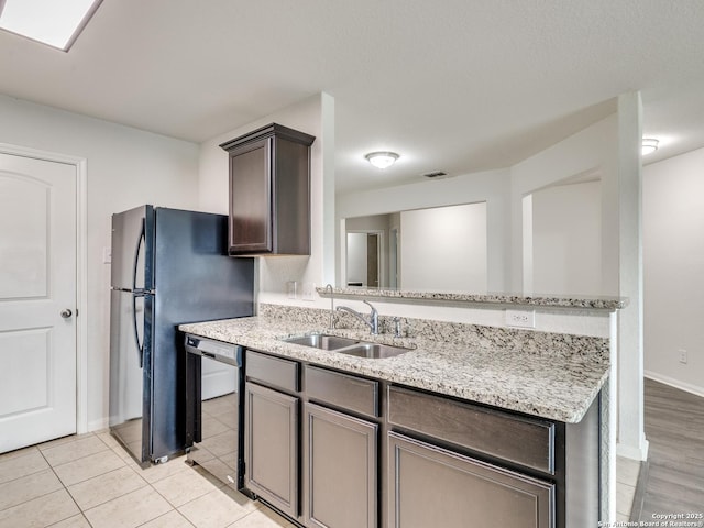 7071 Capeshaw, San Antonio, TX 78252 - kitchen with a sink, dishwasher, light stone counters, baseboards, and freestanding refrigerator