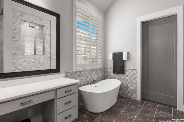 17918 Cantera Ct, San Antonio, TX 78255 - bathroom with tile walls, a soaking tub, marble look tile flooring, vanity, and a wainscoted wall