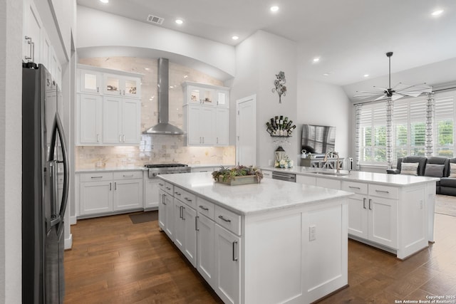 17918 Cantera Ct, San Antonio, TX 78255 - kitchen with wall chimney range hood, appliances with stainless steel finishes, a sink, a kitchen island, and white cabinetry