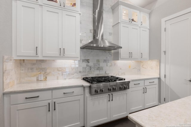 17918 Cantera Ct, San Antonio, TX 78255 - kitchen featuring stainless steel gas stovetop, wall chimney range hood, white cabinets, tasteful backsplash, and glass insert cabinets