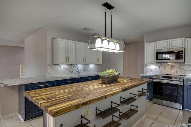 1632 Dogwood Ln, Schertz, TX 78154 - kitchen featuring stainless steel appliances, butcher block counters, blue cabinetry, white cabinets, and decorative backsplash