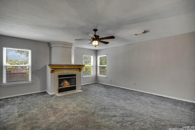 1632 Dogwood Ln, Schertz, TX 78154 - unfurnished living room featuring carpet floors, a ceiling fan, a textured ceiling, a fireplace with flush hearth, and baseboards