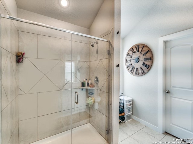 1136 Amber Lk, Seguin, TX 78155 - bathroom featuring tile patterned floors, a stall shower, baseboards, and a textured ceiling