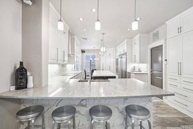 2834 Olive Ave, Schertz, TX 78154 - kitchen with recessed lighting, a peninsula, a breakfast bar, a sink, and black electric stovetop
