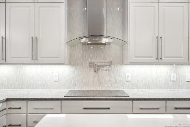 2834 Olive Ave, Schertz, TX 78154 - kitchen with wall chimney range hood, black electric cooktop, white cabinetry, and tasteful backsplash