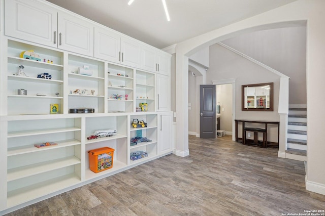 2834 Olive Ave, Schertz, TX 78154 - unfurnished room featuring arched walkways, baseboards, wood finished floors, and stairway