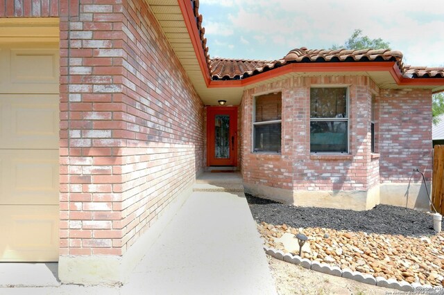 7410 Tom Watson, San Antonio, TX 78244 - entrance to property featuring a tiled roof, brick siding, and an attached garage