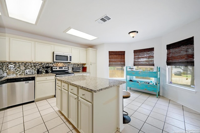 7410 Tom Watson, San Antonio, TX 78244 - kitchen with stainless steel appliances, light tile patterned floors, backsplash, and a center island