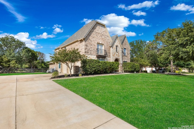 11227 Raw Sienna, Helotes, TX 78023 - view of side of home with a balcony, brick siding, and driveway