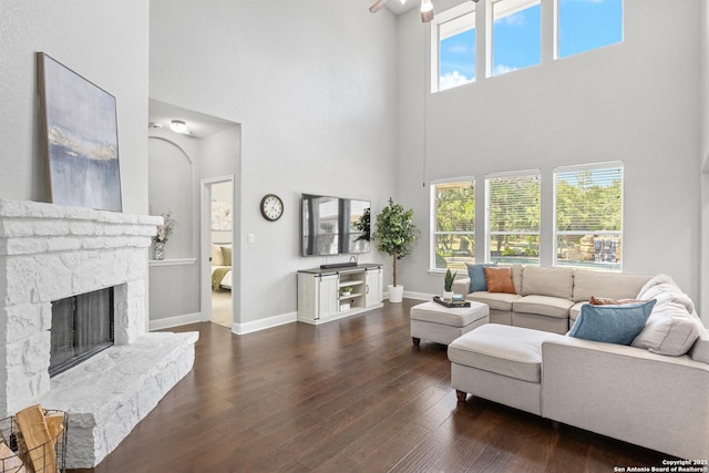 11227 Raw Sienna, Helotes, TX 78023 - living room with a towering ceiling, baseboards, a fireplace, and wood finished floors