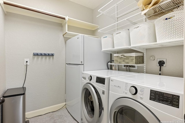 11227 Raw Sienna, Helotes, TX 78023 - laundry room with washer and clothes dryer, baseboards, a textured wall, and light colored carpet