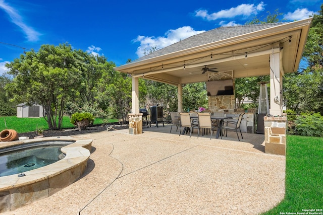 11227 Raw Sienna, Helotes, TX 78023 - view of patio with outdoor dining space, a ceiling fan, an in-ground hot tub, a stone fireplace, and a gazebo