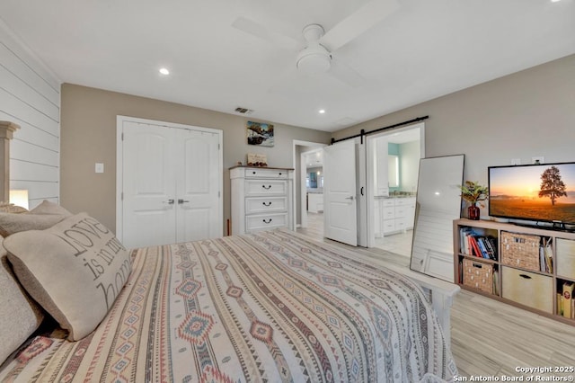 15592 Miller, Saint Hedwig, TX 78152 - bedroom featuring light wood-type flooring, a barn door, a closet, connected bathroom, and recessed lighting