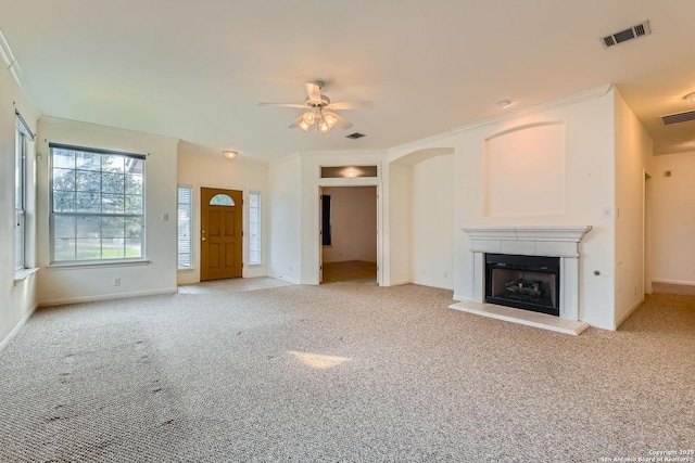 2510 Sage Holw, San Antonio, TX 78251 - unfurnished living room featuring a ceiling fan, light colored carpet, a fireplace with raised hearth, and ornamental molding