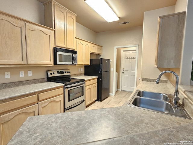 2115 Bentwood, New Braunfels, TX 78130 - kitchen with stainless steel appliances, light brown cabinetry, a sink, light tile patterned floors, and light countertops