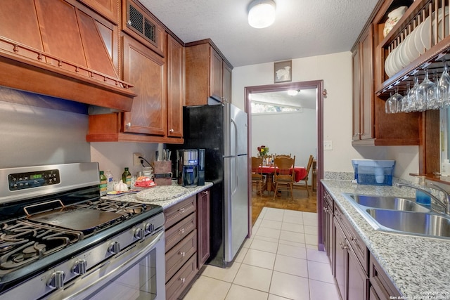 243 Future Dr, San Antonio, TX 78213 - kitchen with stainless steel appliances, a sink, exhaust hood, light tile patterned floors, and a textured ceiling