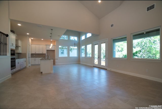 8119 Ventura Blvd, Selma, TX 78154 - unfurnished living room featuring baseboards, high vaulted ceiling, recessed lighting, and a sink