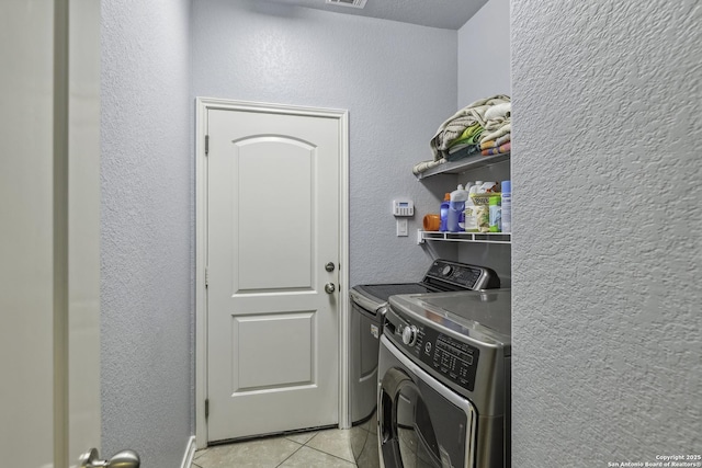 18131 Muir Glen Dr, San Antonio, TX 78257 - laundry room with washer and clothes dryer, light tile patterned flooring, and a textured wall