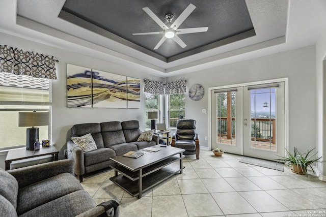 18131 Muir Glen Dr, San Antonio, TX 78257 - tiled living area with a tray ceiling, french doors, a ceiling fan, and baseboards