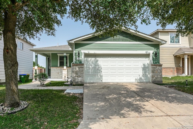 1023 Sundance Fall, San Antonio, TX 78245 - view of front of property featuring stone siding, a garage, concrete driveway, a front lawn, and covered porch