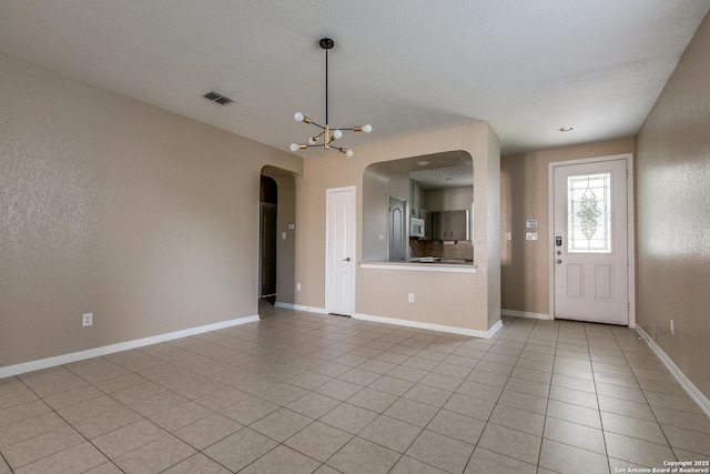 1023 Sundance Fall, San Antonio, TX 78245 - entryway with arched walkways, a chandelier, light tile patterned flooring, and baseboards