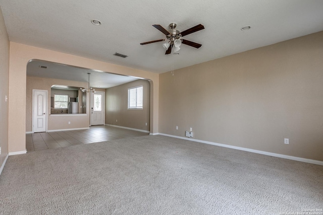 1023 Sundance Fall, San Antonio, TX 78245 - unfurnished living room featuring carpet flooring, a ceiling fan, arched walkways, baseboards, and a chandelier