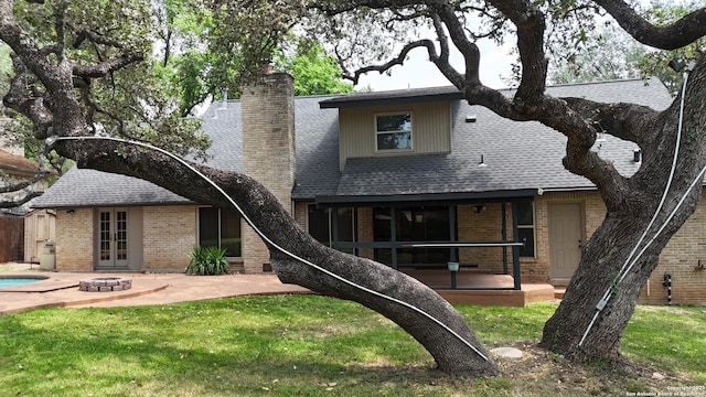 2922 Low Oak St, San Antonio, TX 78232 - back of property with a patio, a chimney, an outdoor fire pit, brick siding, and a lawn