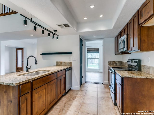 2922 Low Oak St, San Antonio, TX 78232 - kitchen featuring stainless steel appliances, a sink, light stone countertops, a peninsula, and light tile patterned floors