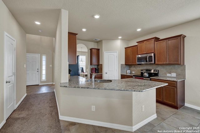 1902 Kalli Jo, New Braunfels, TX 78130 - kitchen with stainless steel appliances, a sink, a peninsula, light stone counters, and backsplash